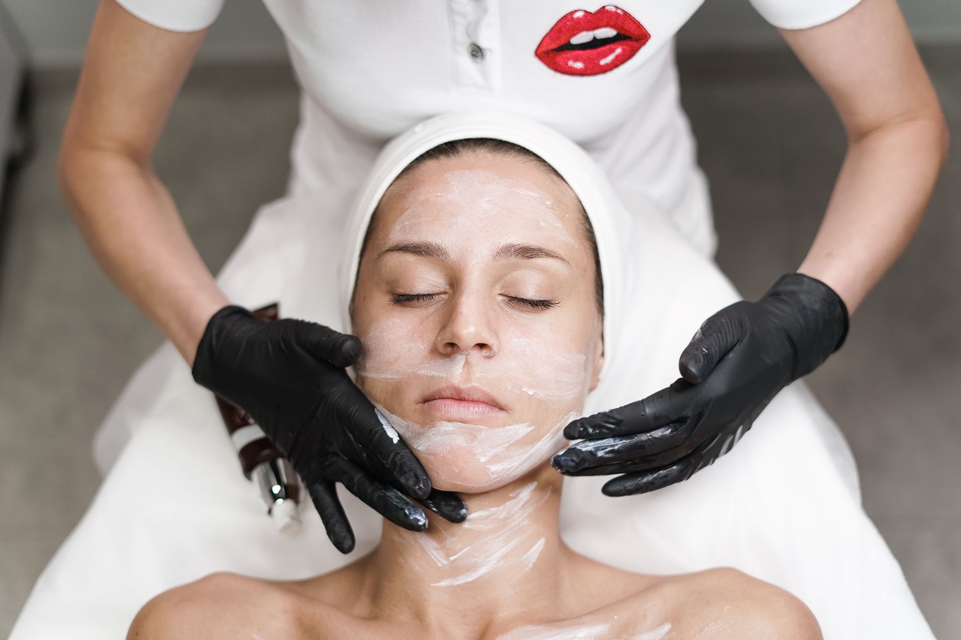 femme recevant un soin du visage dans un spa avec une estheticienne appliquant un masque dans un cadre relaxant