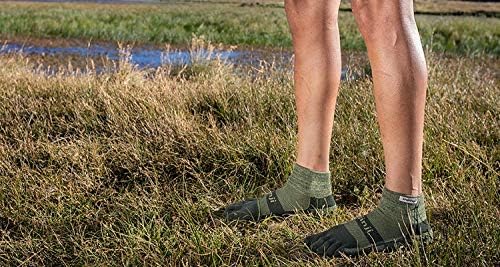 Piedi con calze a 5 dita Injinji verdi su un prato