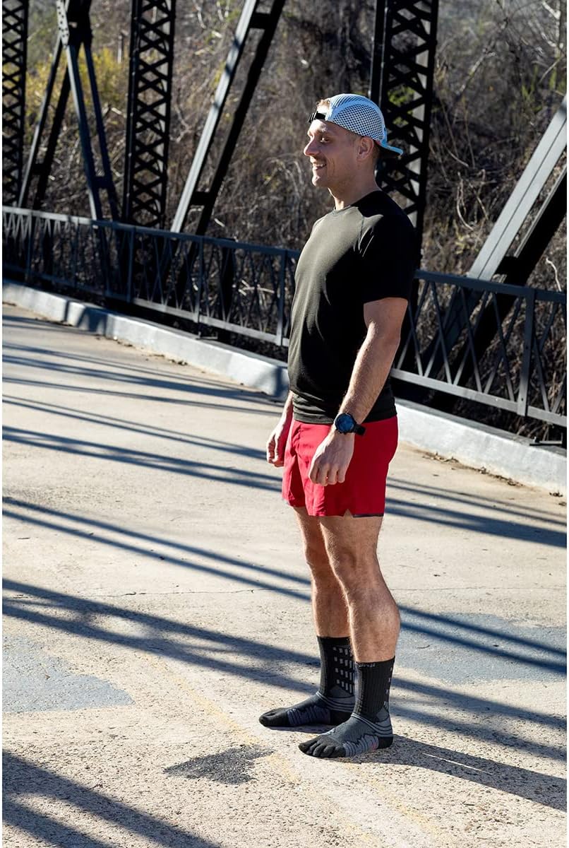 Runner in piedi su un ponte con calze Injinji Ultra Run nere