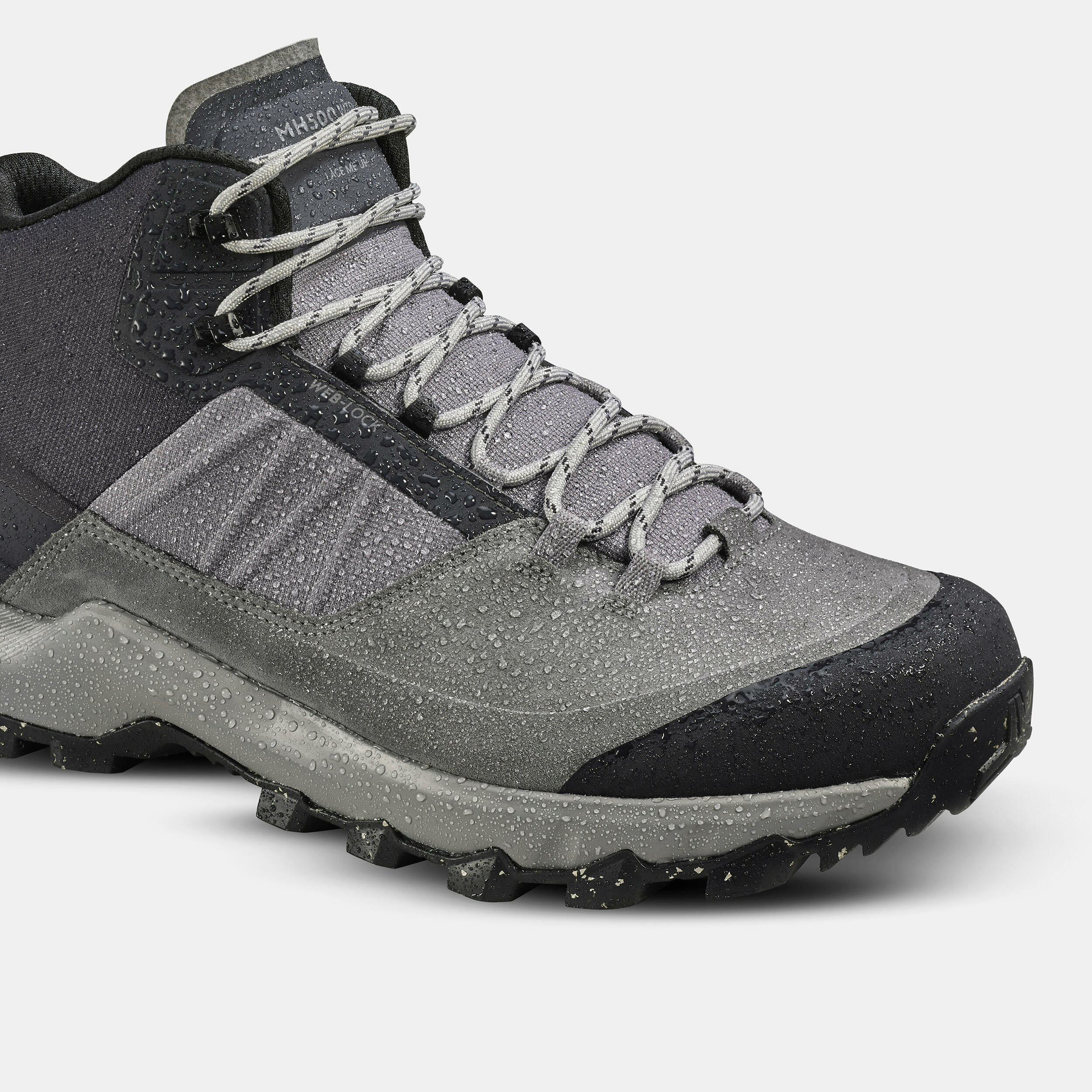 Tomaia in cuoio grigio della Quechua MH500 Mid bagnata da gocce dacqua, con parapietre nero in punta