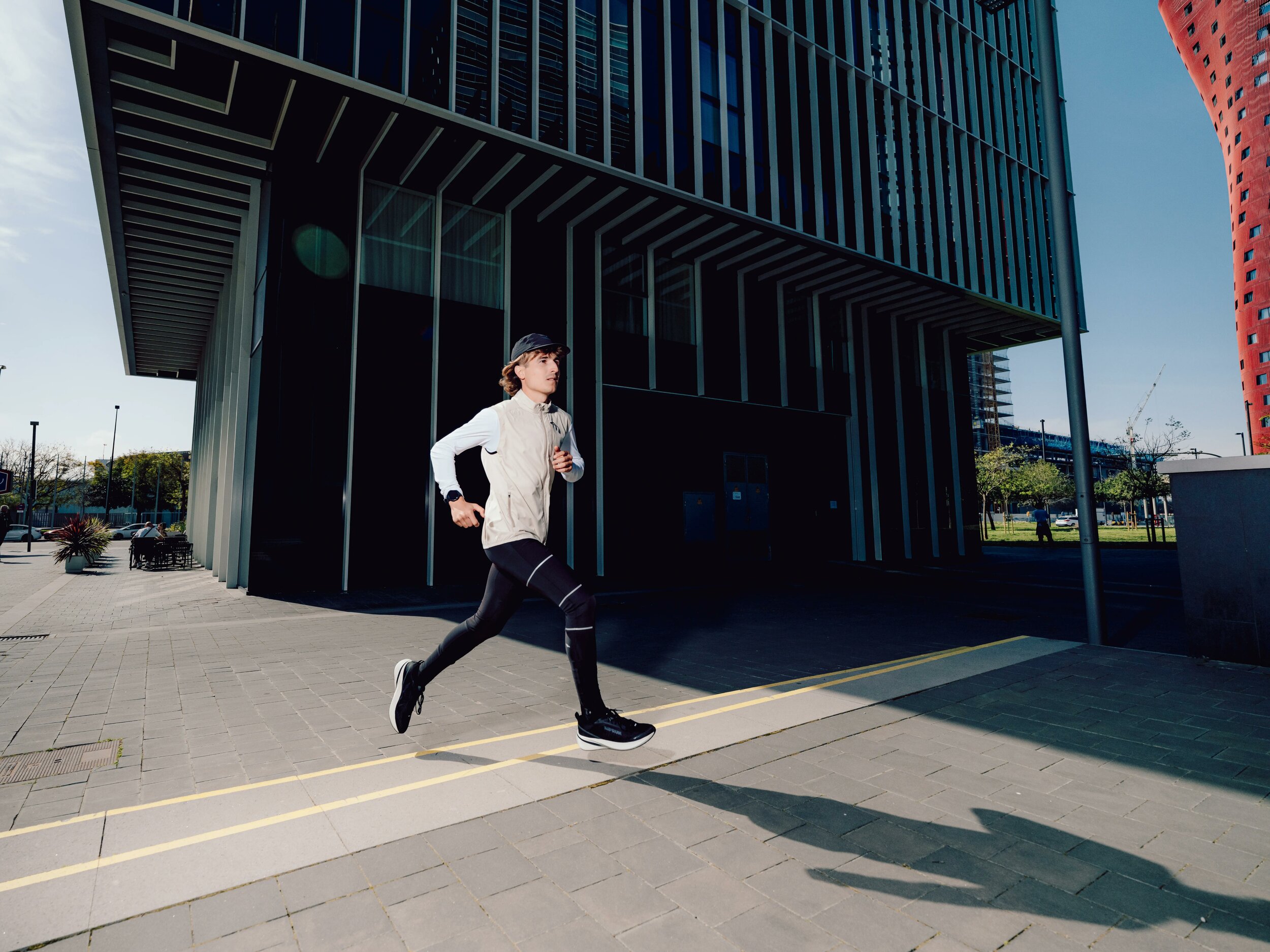 Runner che corre su un marciapiede in città con le scarpe Kiprun Kipcore