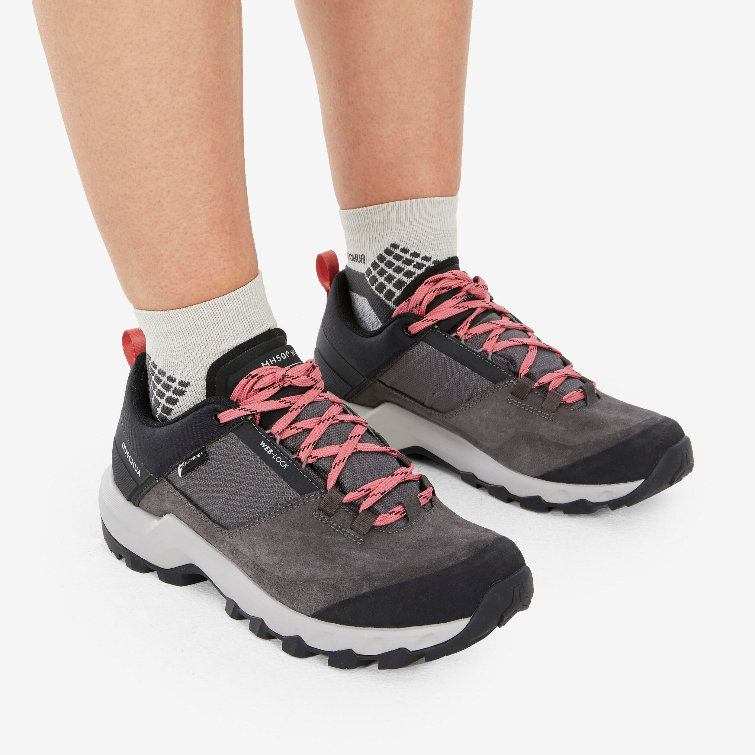 Piedi con calze da trekking e scarpe basse Quechua MH500 Low grigie e rosa