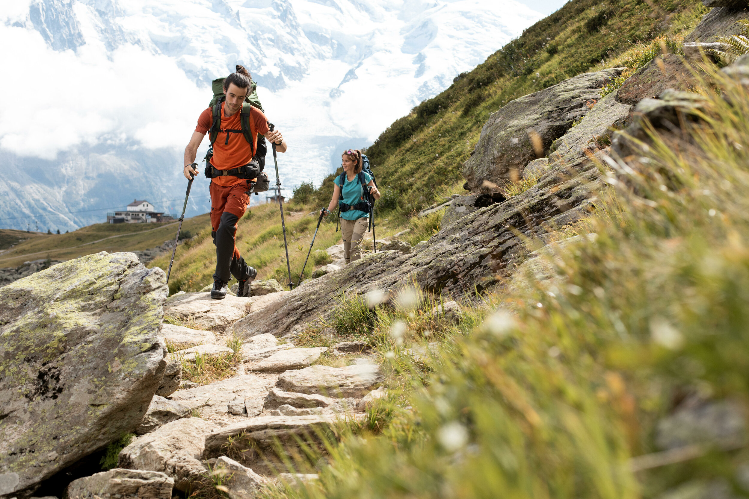 Due escursionisti con bastoncini su un sentiero di pietre in alta montagna