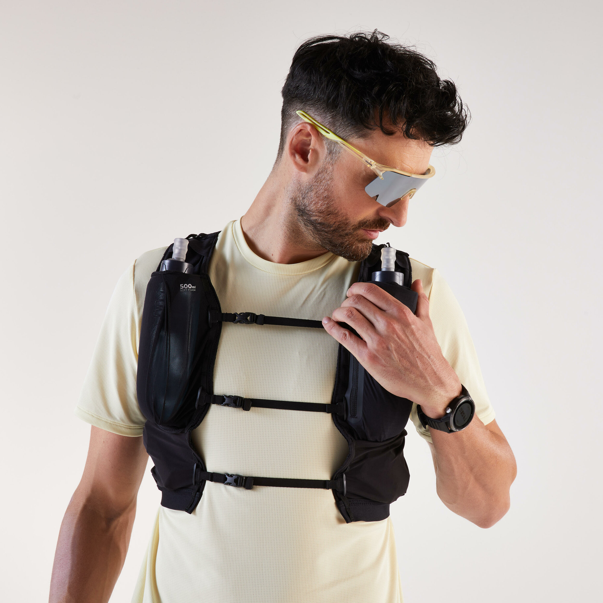 Runner che indossa il gilet Kiprun 900 Race con due flask nelle tasche frontali