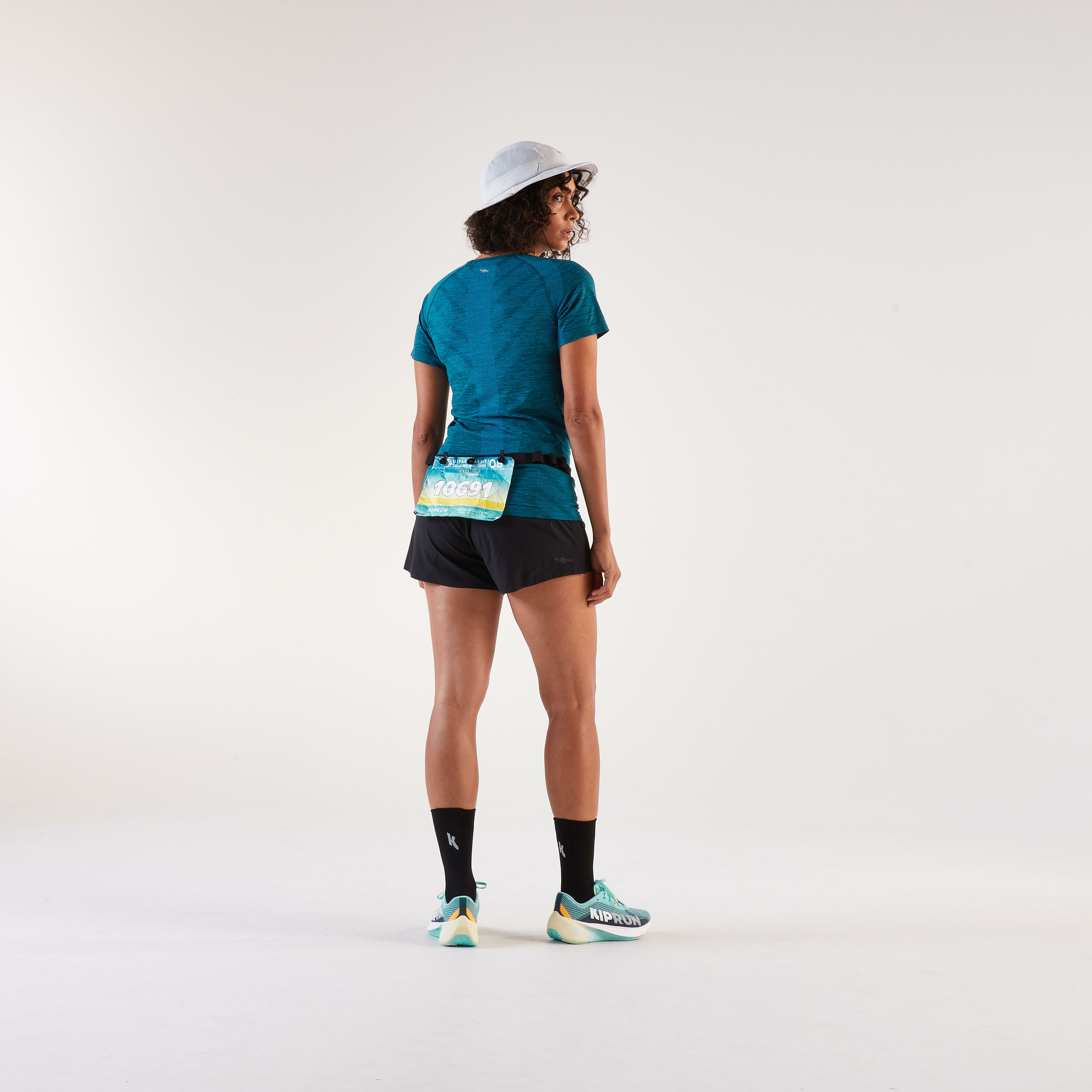 Runner vista di spalle con la cintura Kiprun ruotata e il pettorale sul retro