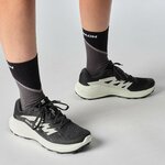 Runner con Salomon Alphaglide nere ai piedi e calze alte
