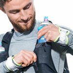 Runner che sistema una borraccia nella tasca dello spallaccio Deuter