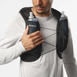 Runner che prende un flask dalla tasca sul petto del gilet Salomon