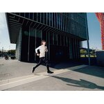 Runner che corre su un marciapiede in città con le scarpe Kiprun Kipcore