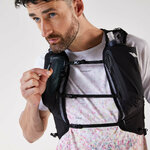 Runner che sistema una flask da 500 ml nella tasca frontale dello zaino Kiprun 900