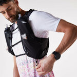 Runner che apre la zip della tasca laterale dello zaino Kiprun 900 indossato