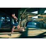 Runner che corre veloce sotto una struttura in acciaio in città