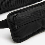 Primo piano della tasca frontale con zip della cintura Kiprun in tessuto ripstop nero