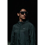 Runner con occhiali sportivi e giacca Kiprun Run Flow su sfondo scuro