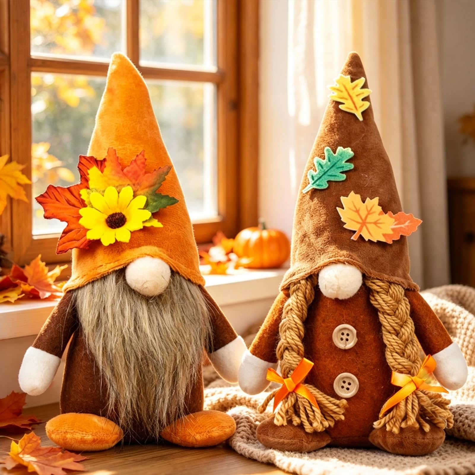 Zwei Stoffwichtel mit orangefarbener und brauner Mütze, verziert mit Sonnenblume und Ahornblättern