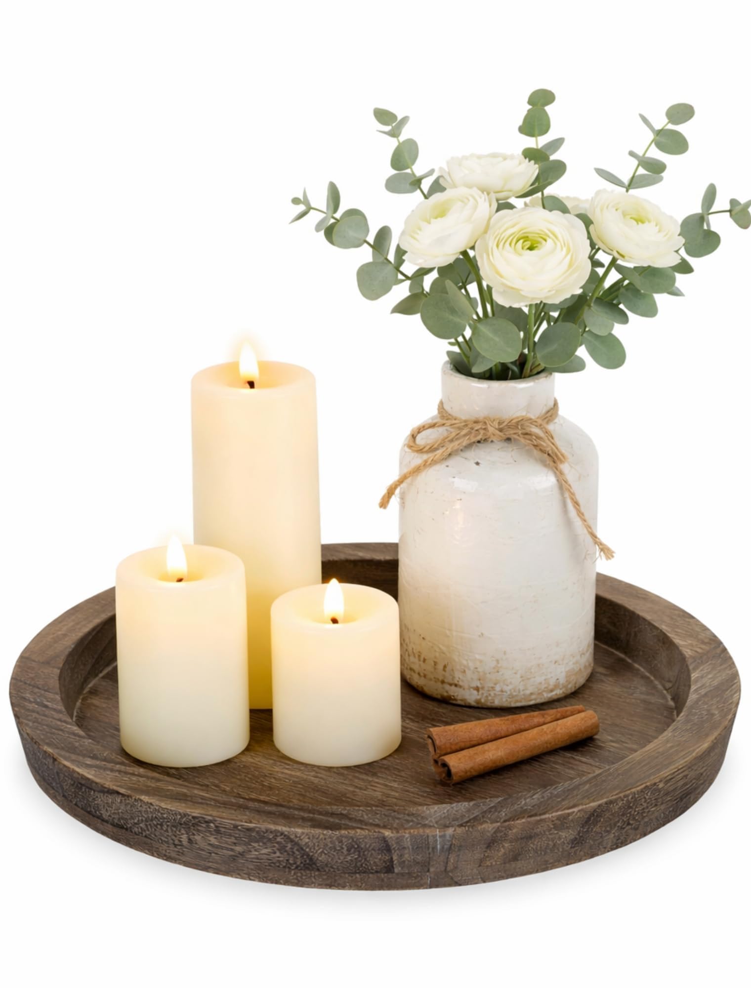 Rundes Holztablett mit LED-Stumpenkerzen, weißer Vase mit Blumen und Zimtstangen
