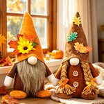 Zwei Stoffwichtel mit orangefarbener und brauner Mütze, verziert mit Sonnenblume und Ahornblättern