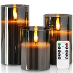 Drei LED-Kerzen in grauen Gläsern in drei Höhen mit warmgelbem Licht
