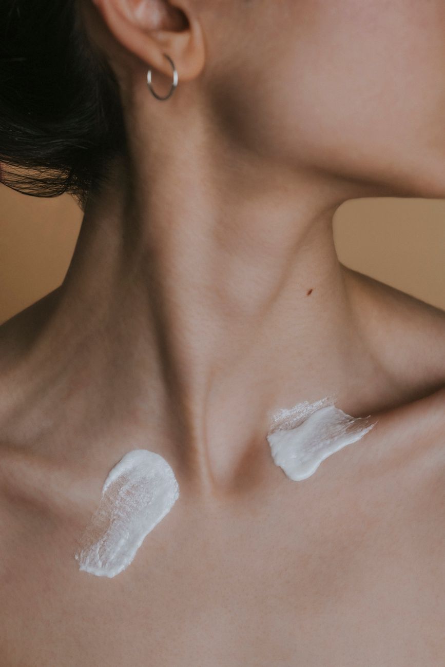 image detaillee montrant le cou d une femme avec de la creme pour le soin de la peau appliquee dans un environnement de studio
