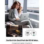 Voyageuse chargeant son ordinateur au bureau avec le chargeur 65 W