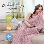 Voyageuse enveloppée dans la couverture de voyage sur un canapé