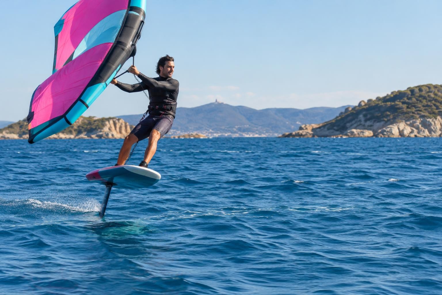 Rider de wing foil en vol au-dessus de l'eau dans la baie d'Hyères