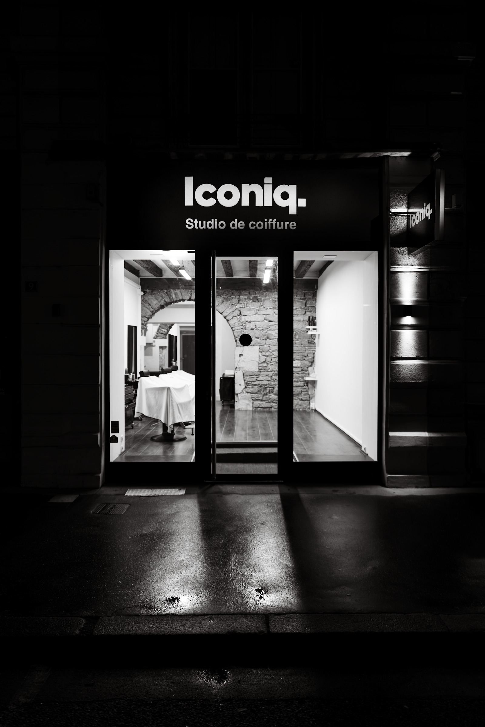 Devanture du salon ICONIQ, barbier et studio de coiffure au 9 quai des Célestins à Lyon, de nuit