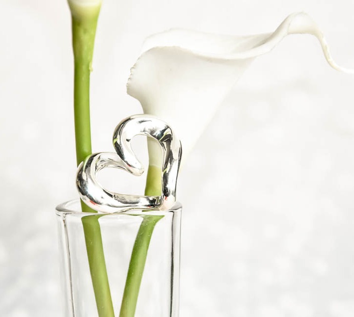 coeur en argent présenté sur un vase transparent et un arome en décor