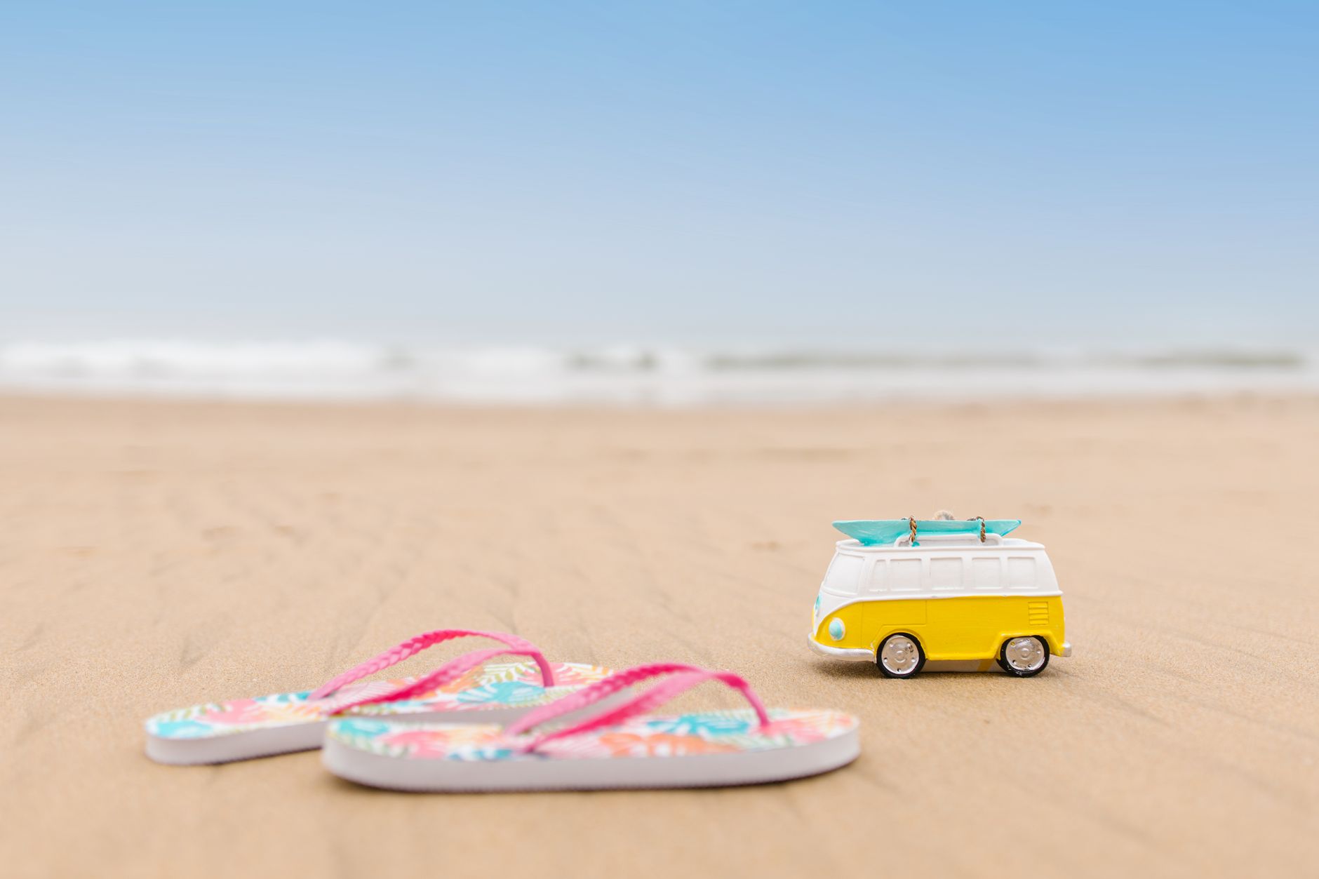 des tongs vibrantes et une camionnette jouet ludique sur une plage de sable parfait pour des vibes de vacances
