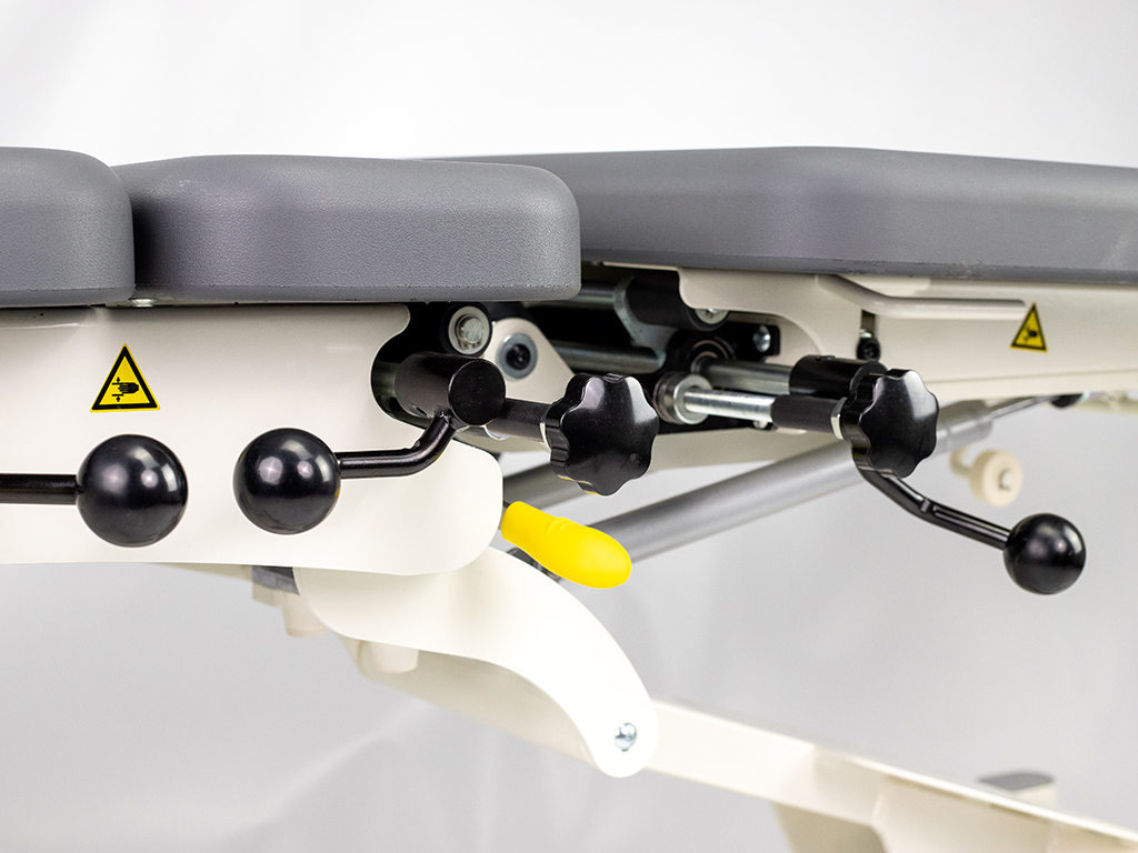 table de chiropraxie électrique habys avec drops ou toggle mécaniques vue levier drop couleur grise