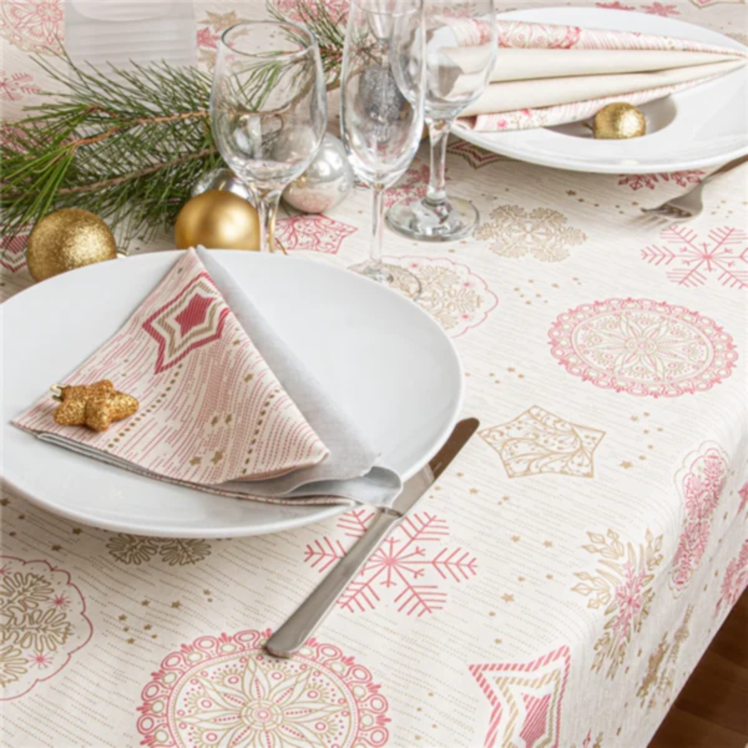 Table de Noël dressée avec la nappe effet tissu à flocons, assiettes, couverts et décorations