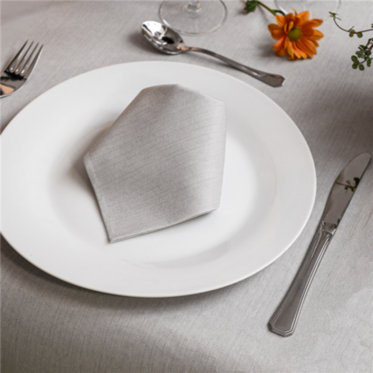Table carrée dressée avec la nappe effet tissu grise 100 x 100 cm, assiettes, verres et couverts
