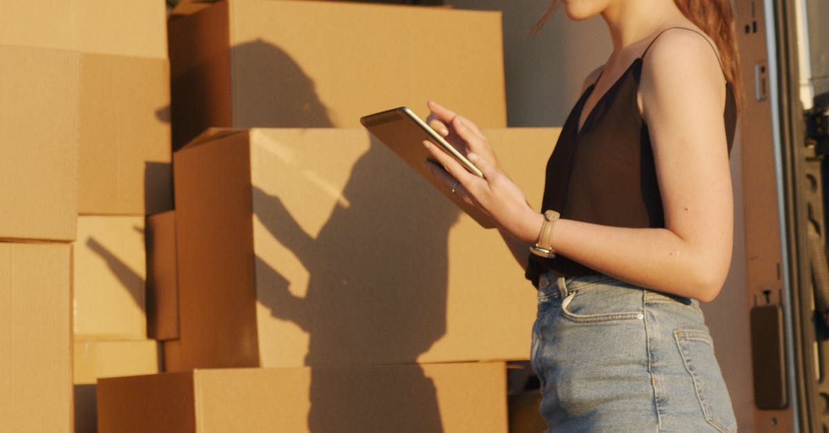 femme en jean bleu et casquette blanche tenant une boite en carton