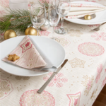 Table de Noël dressée avec la nappe effet tissu à flocons, assiettes, couverts et décorations
