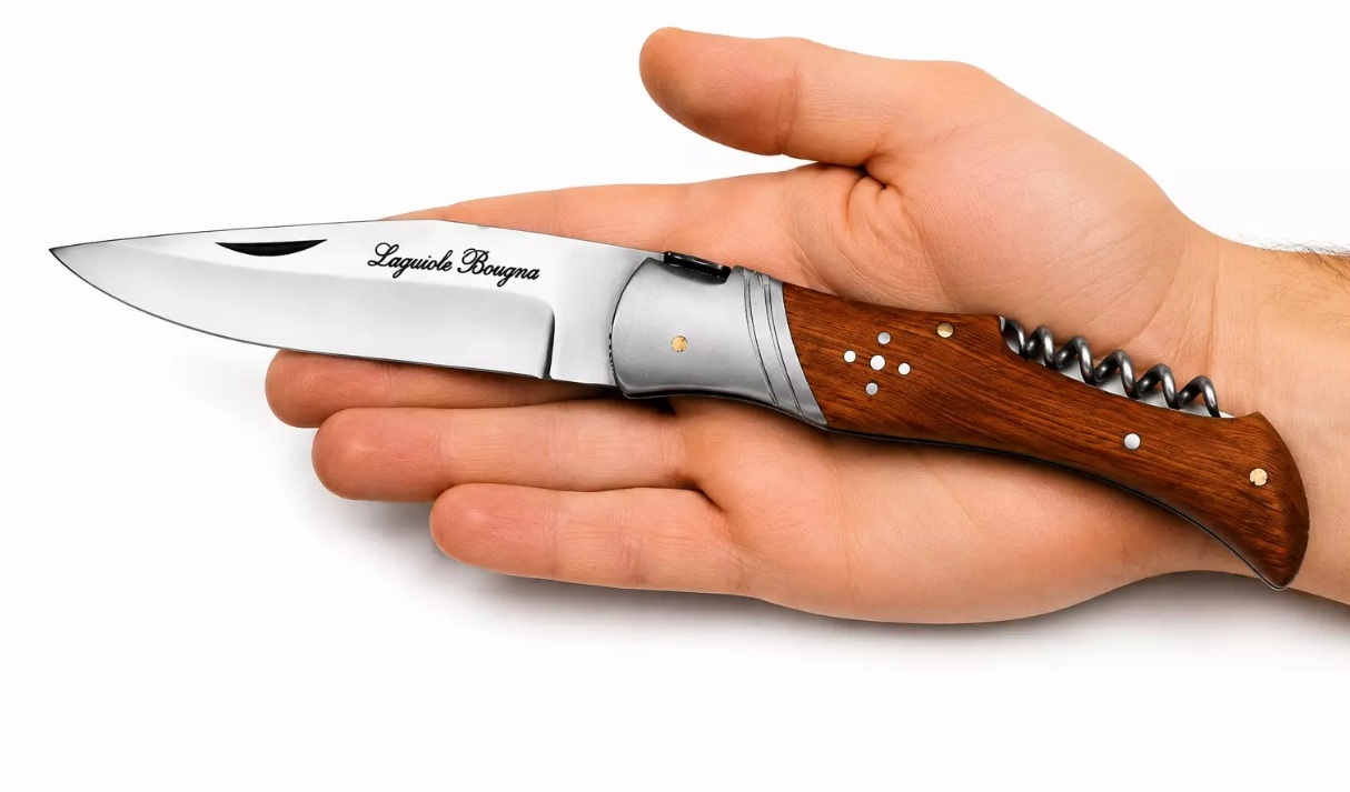 Couteau Laguiole pliant manche bois de teck tenu dans une main