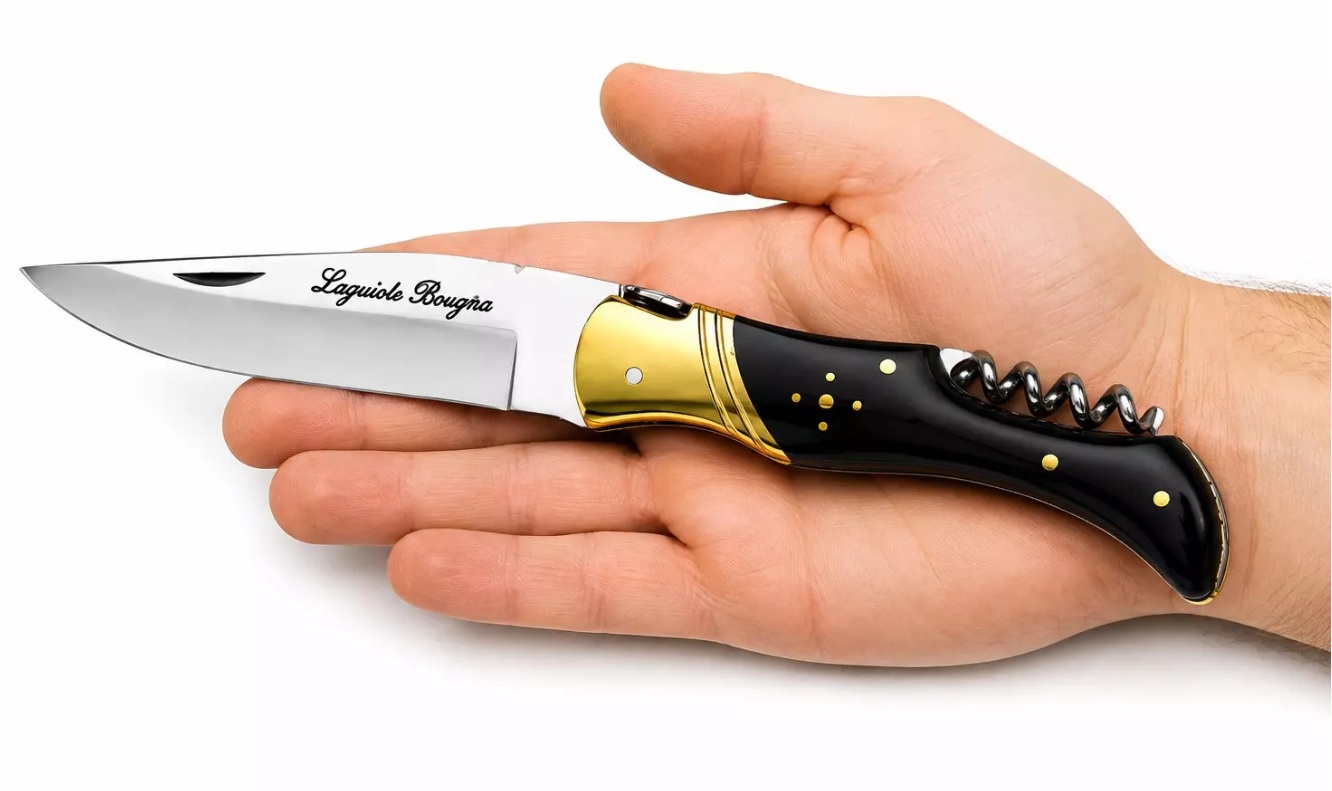 couteau laguiole pliant corne noire dans la main avec tire-bouchon intégré et lame inox de prestige