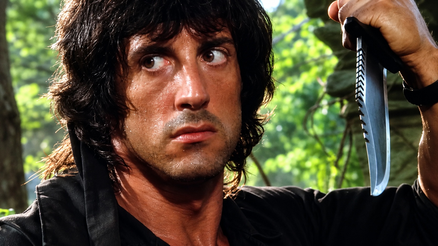 Rambo dans la jungle tenant son célèbre couteau de survie First Blood Part II