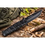 Couteau pliant de poche SCH noir posé sur un tronc darbre pour le camping et le bushcraft