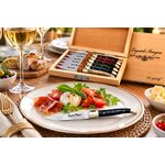 Couteau apéritif Laguiole Bougna en laiton et bois coloré présenté sur une assiette élégante lors dun repas gastronomique.