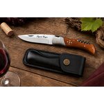Couteau Laguiole pliant manche bois de teck avec étui noir présenté sur une table de dégustation de vin