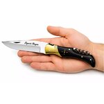 couteau laguiole pliant corne noire dans la main avec tire-bouchon intégré et lame inox de prestige