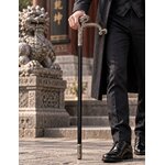Homme élégant tenant une canne épée dragon de luxe devant un temple asiatique
