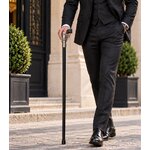 Homme en costume portant une canne épée revolver noire, accessoire de marche raffiné au style gentleman.