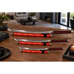 Ensemble katana wakizashi et tanto rouges exposés dans un salon moderne sur table en bois