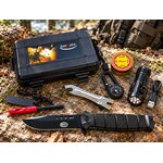 Kit de survie complet avec couteau et accessoires posé en forêt