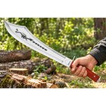 Machette sabre Dragon Albainox 60 cm tenue en main dans une forêt, avec lame décorée et manche en bois.