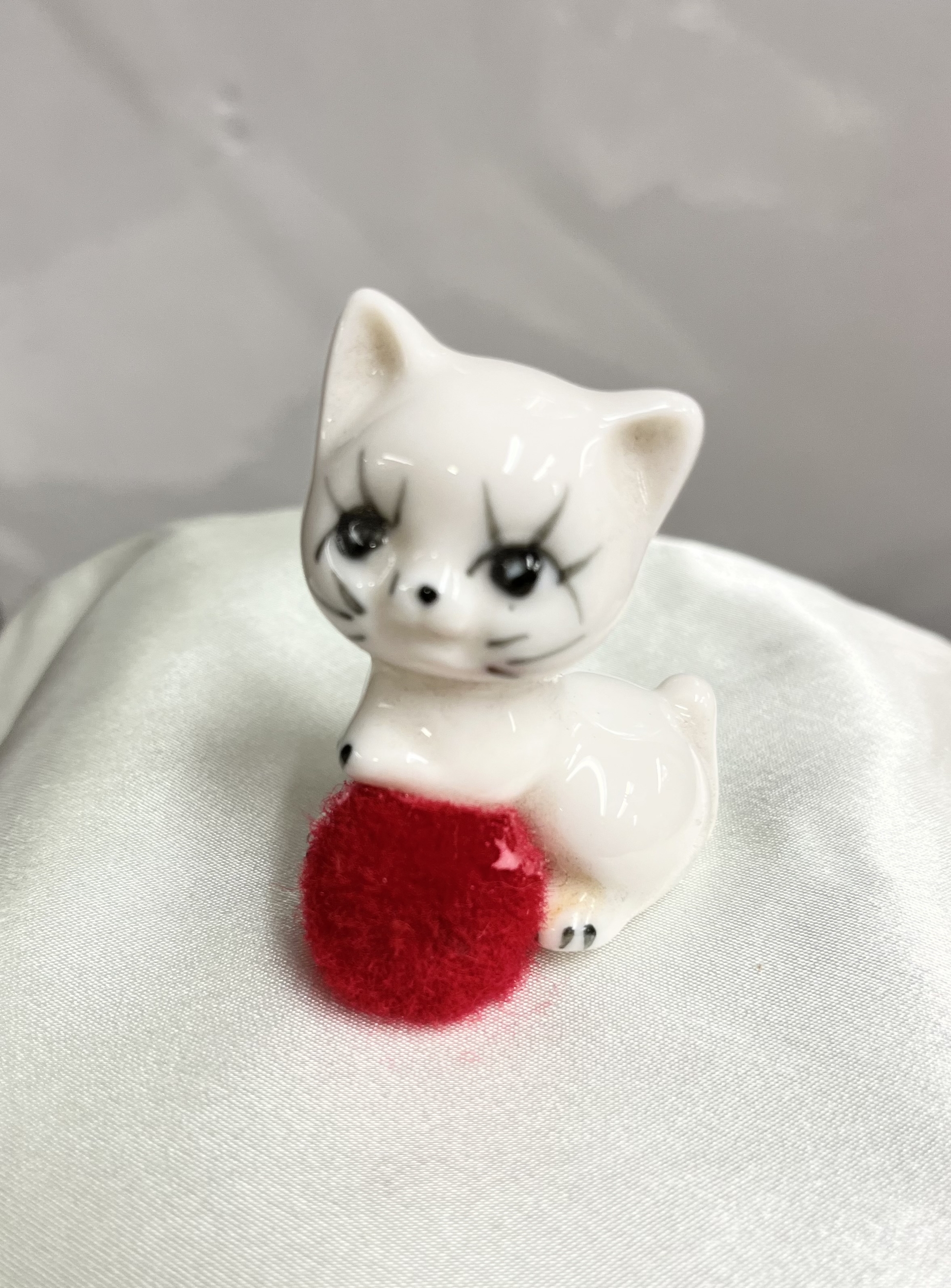 chat porcelaine pompon rouge