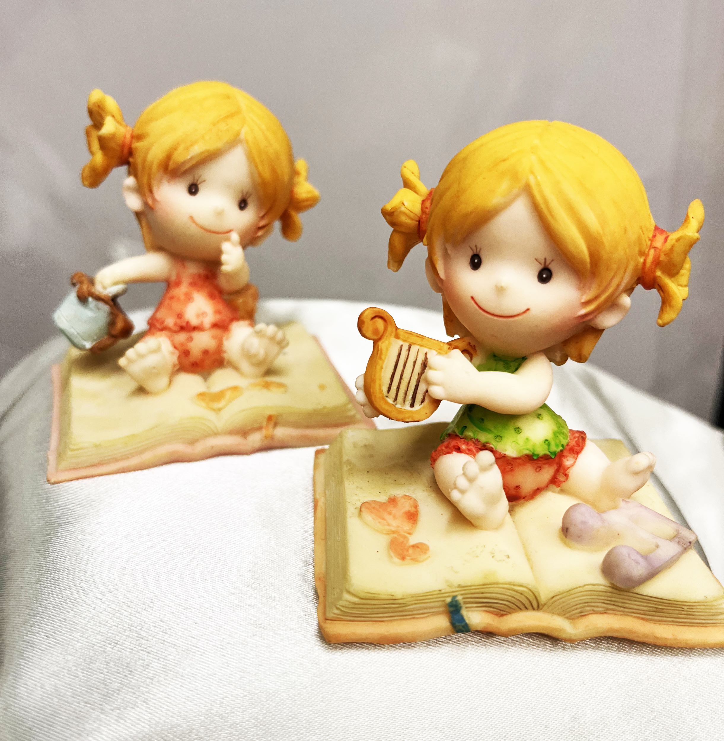 2 figurines bebe fille sur coussin