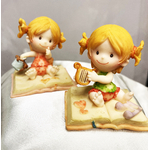 2 figurines bebe fille sur coussin