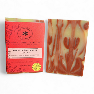 Savon Grenade et Beurre de Mangue artisanal, avec son emballage rouge et sa barre marbrée rouge et ivoire.